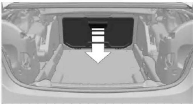 Interior view of a car showing the rear bumper and side panel, with a white arrow pointing to a specific area (no text or symbols visible)
