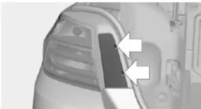 Close-up of a car's front bumper with two white arrows pointing to the side panel (no text or symbols visible)