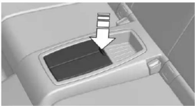 Close-up of a car interior with a hand pointing to a drain component (no text or symbols visible)