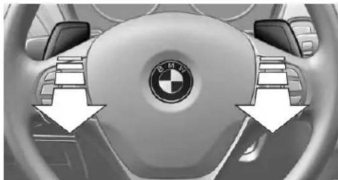 Interior view of a BMW car dashboard showing the wheel, steering wheel, and logo (no text or symbols visible)