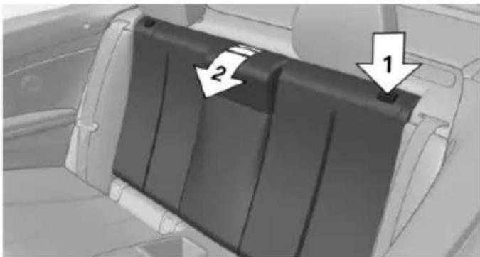 Interior view of a car showing a black plastic panel with two arrows pointing to specific parts (no text or symbols present)