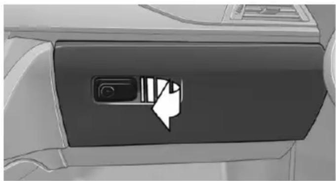 Close-up of a car's front panel showing a mouse cursor icon pointing to the button (no text or symbols visible)