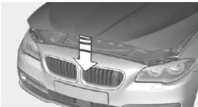 Front view of a silver BMW sedan with grille grilles and a white arrow pointing to the grille (no text or symbols visible)