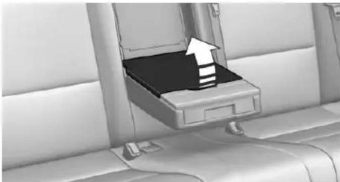 Interior view of a car seat with an open drawer containing a black tray and a white upward arrow indicating direction (no text or symbols)
