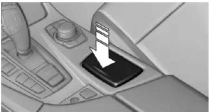 Close-up of a car gear shift lever with a white downward arrow indicating motion (no text or symbols)