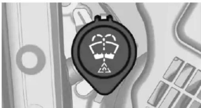 Close-up of a black circular device with a white warning symbol on its face, surrounded by abstract geometric patterns (no readable text or symbols)