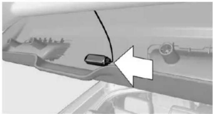 Close-up of a car's front panel showing a cable and a connector, with an arrow pointing to the connector (no text or symbols visible)