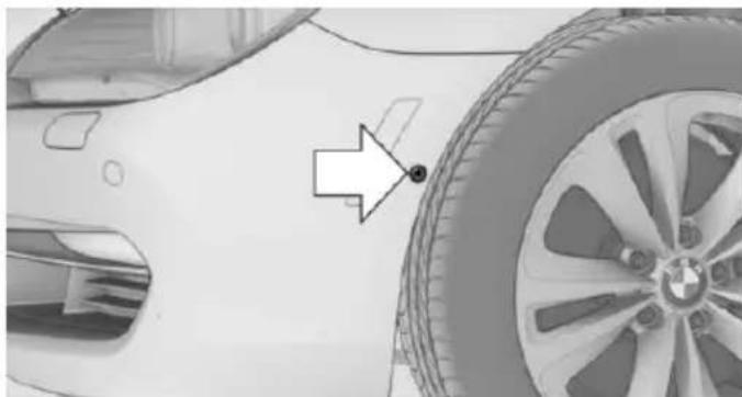 Side view of a car's front wheel and side panel, showing a white car body and a red arrow pointing to the wheel (no text or symbols visible)
