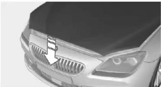 Front view of a car's head with grille and headlights, showing a white arrow pointing to the grille (no text or symbols visible)
