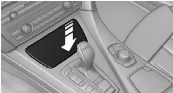 Interior view of a car dashboard with a black play button and white directional arrow (no text or symbols)
