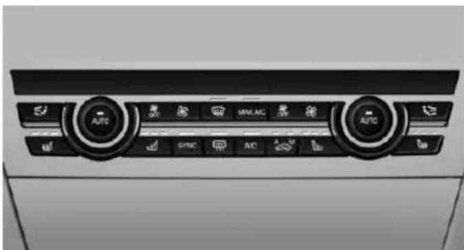Interior view of a car air conditioning unit with dual rotary controls and function buttons (no readable text or symbols)