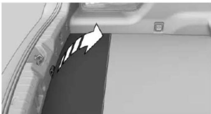Interior view of a vehicle showing a car trunk and window with a white arrow pointing to a panel (no text or symbols visible)