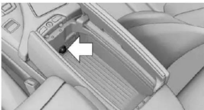 Interior view of a car headrest with a white arrow pointing to a button (no text or symbols visible)