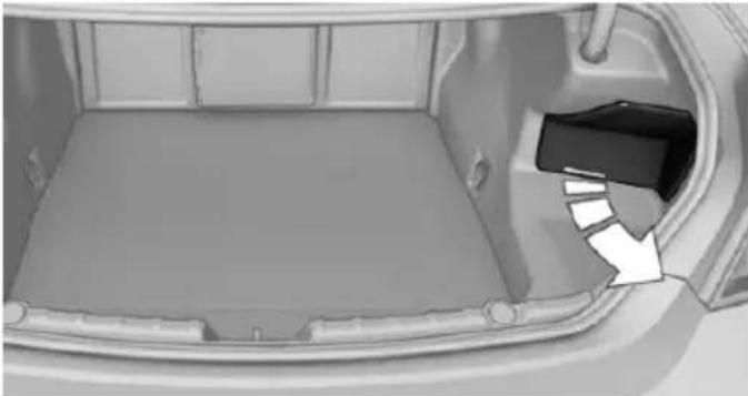 Interior view of a car trunk with a plastic tray and a small black component on the side (no text or symbols visible)