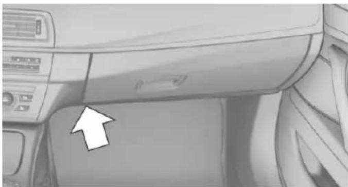 Interior view of a car dashboard with a white arrow pointing to the side panel (no text or symbols visible)