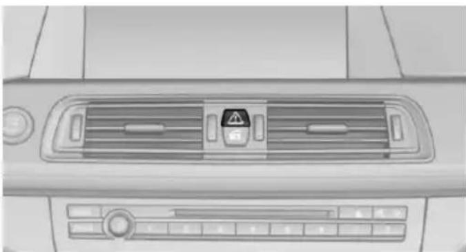 Top-down view of a car air intake console with warning symbol and control buttons (no text or labels visible)