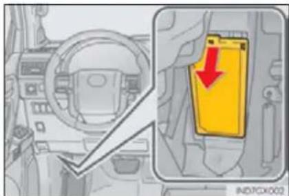 Diagram showing car interior and dashboard with a yellow warning sign indicating a red arrow pointing to a yellow rectangular object.
