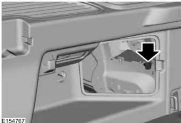 Close-up of a vehicle's front compartment showing a door and window, with a black arrow pointing to a detail (no text or symbols visible)
