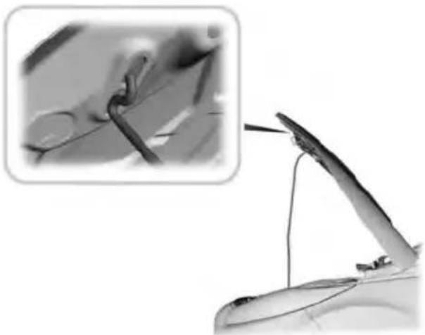 Close-up of a mechanical component with a close-up inset showing a close-up of a tool or wire (no visible text or symbols)