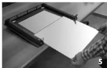 Person holding a blank sheet of paper with a metal frame, no visible text or symbols