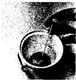 Nahaufnahme einer kleinen Schüssel mit einem eingeführten Löffel, möglicherweise ein Behälter oder Topf (kein sichtbarer Text oder Symbole)
