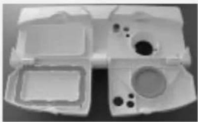 White plastic mechanical housing with multiple compartments and mounting holes (no text or symbols visible)