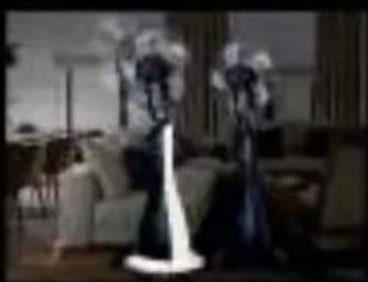 Interior scene with two people standing in a dimly lit room, one illuminated and the other glowing (no visible text or symbols)