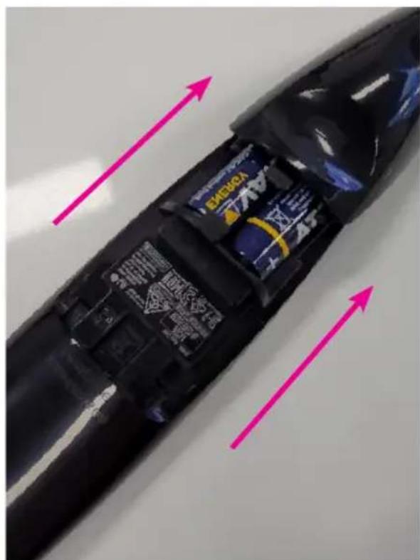 Close-up of a black electronic device with visible internal components and pink directional arrows indicating motion or flow.