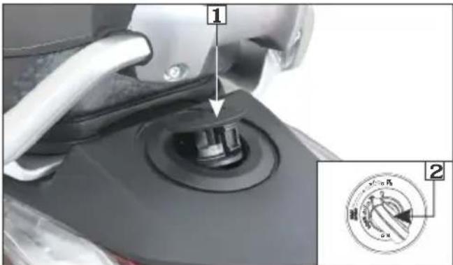 Diagram showing a mechanical component with labeled parts and an inset circular dial indicating rotation direction.