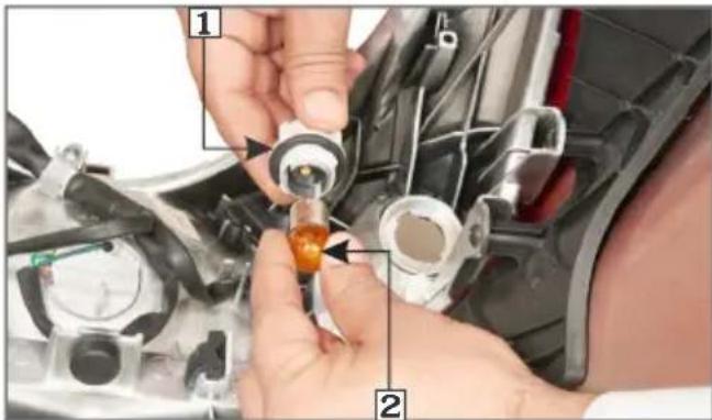 Close-up of hands installing or adjusting a mechanical component with numbered parts labeled 1 and 2