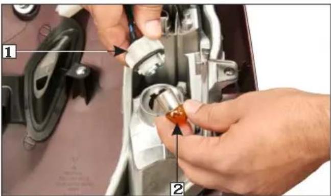 Close-up of hands installing a mechanical component with numbered parts labeled 1 and 2