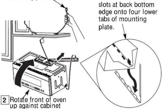 slots at back bottom edge onto four lower tabs of mounting plate. 2 Rotate front of oven up against cabinet