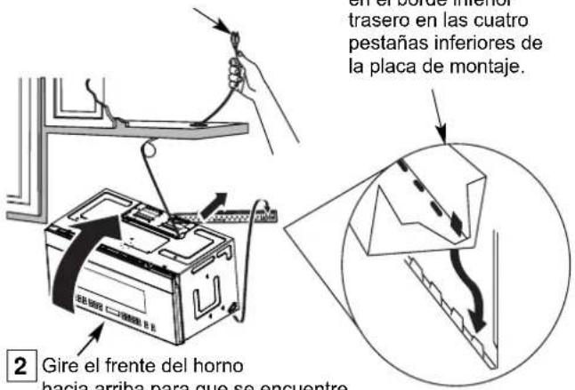 en el bordo interior trasero en las cuatro pestañas inferiores de la placa de montaje. 2 Gire el frente del horno hacia arriba para que se encuentre