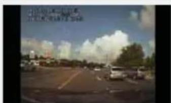 Street photo with visible Chinese text overlay describing a road scene with vehicles and sky background