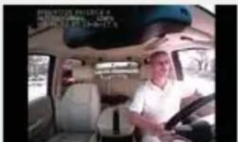 Photo of a man inside a car with visible text overlay in the top-left corner
