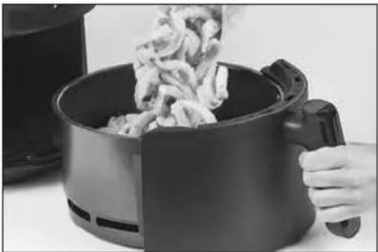 Person cooking air fryer with steaming meat inside a black air fryer (no text or symbols visible)