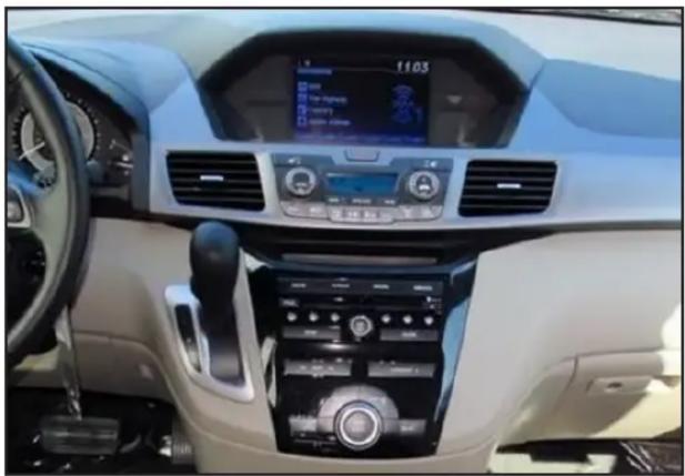 Interior view of a modern car dashboard with digital displays and air conditioners (no visible text or symbols)