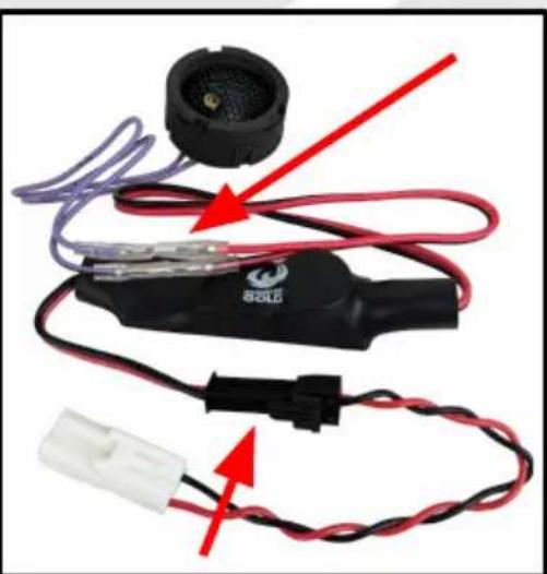 Close-up of a black electrical plug with red and purple wires, connected to a white terminal connector (no text or symbols visible)