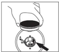 Diagram showing hand holding a container with a dial and pointer, indicating a measurement or control step.