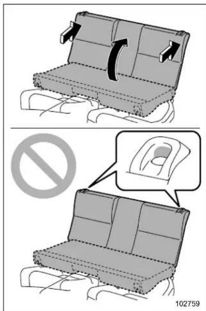 Diagram illustrating seatbelt usage with directional arrows and a prohibition symbol, showing seating arrangement and safety instructions.