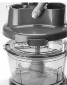 Close-up of a kitchen blender with a hand pressing the top (no visible text or symbols)