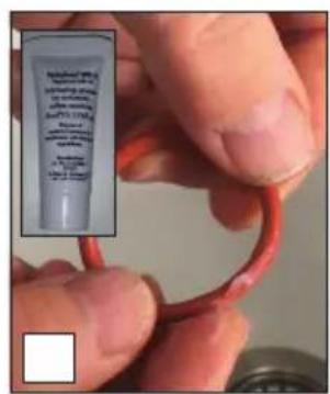 Close-up of a hand holding a red tube with visible text labels, likely indicating a product or sample.