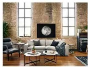 Interior view of a modern living room with brick walls, a sofa, TV, and coffee table (no visible text or symbols)