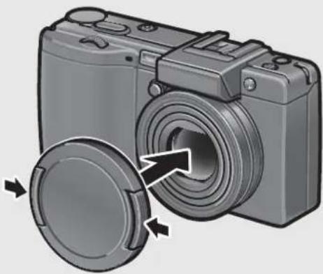RICOH Caplio GX100 VF Kit - Press the tabs on both sides of the lens cap, and attach the lens cap to the camera lens. - 1