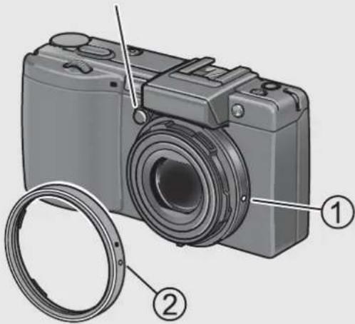 Diagram of a digital camera with labeled parts, showing front and side views and a coiled cable.