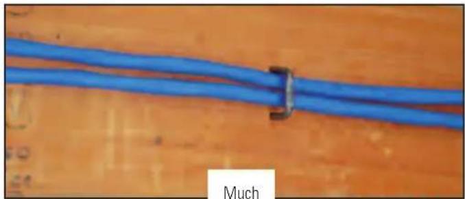 Close-up of two blue cable clips attached to a wooden surface, labeled 'Much' (no other text or symbols visible)