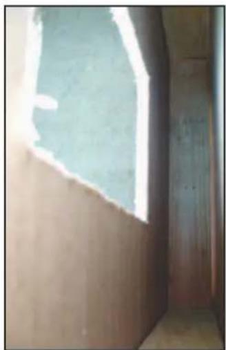 Interior corner of a room with a light-colored window and wooden door, no visible text or symbols