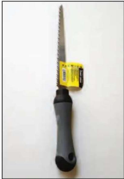Close-up of a black and gray saw with a yellow label on the side (no visible text or symbols on the saw itself)