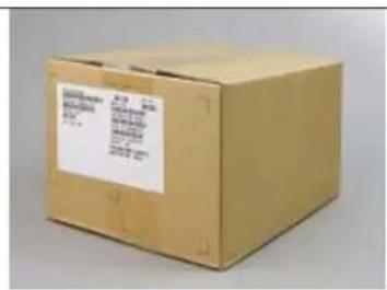 Scanned image of a cardboard box with visible shipping label and printed text on the front panel.