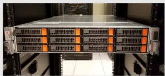 Server rack with orange-labeled drive units and Chinese text indicating system status or data transfer